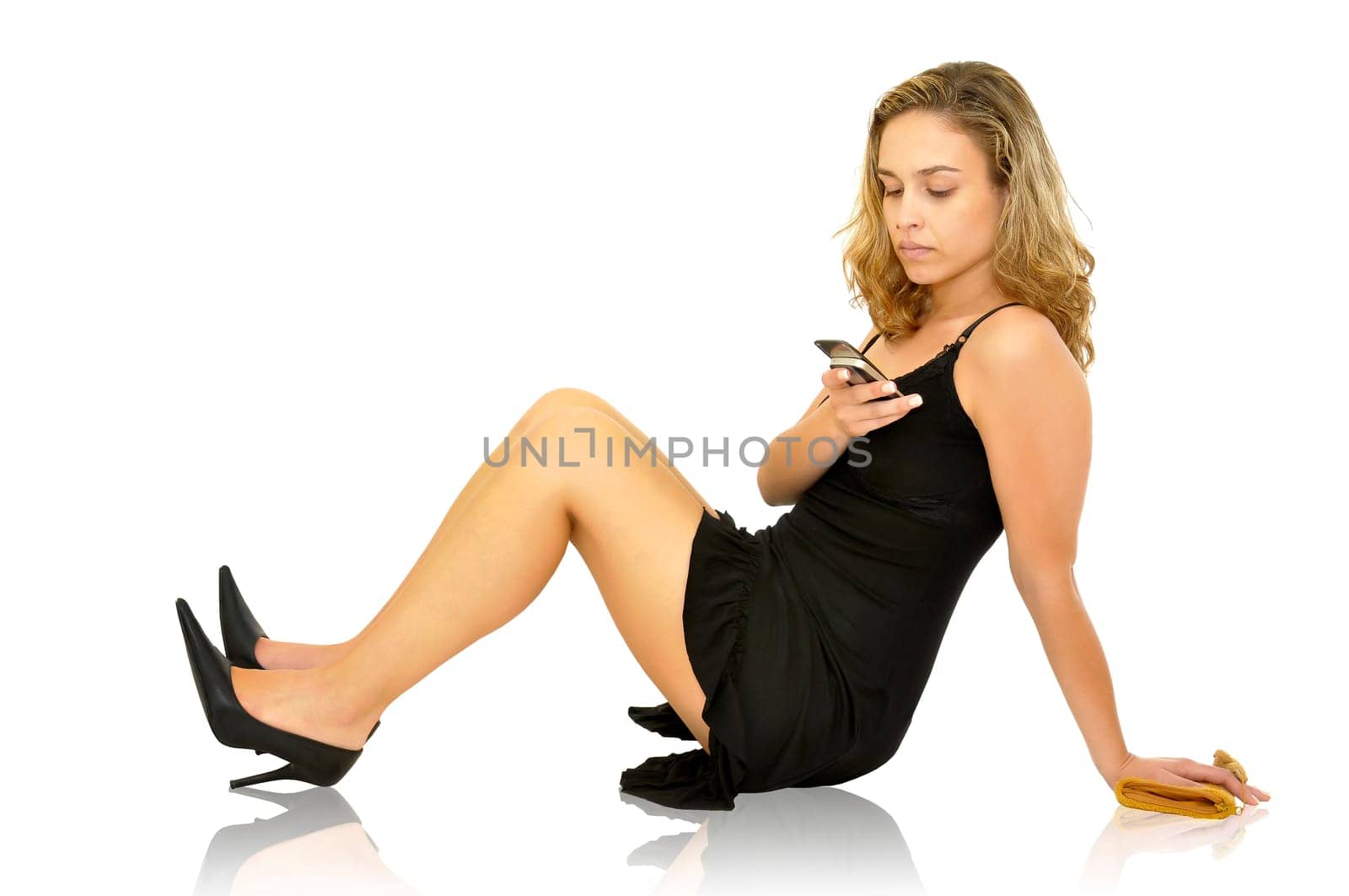 Beautiful young woman posing with a black dress and cellphone isolated in white