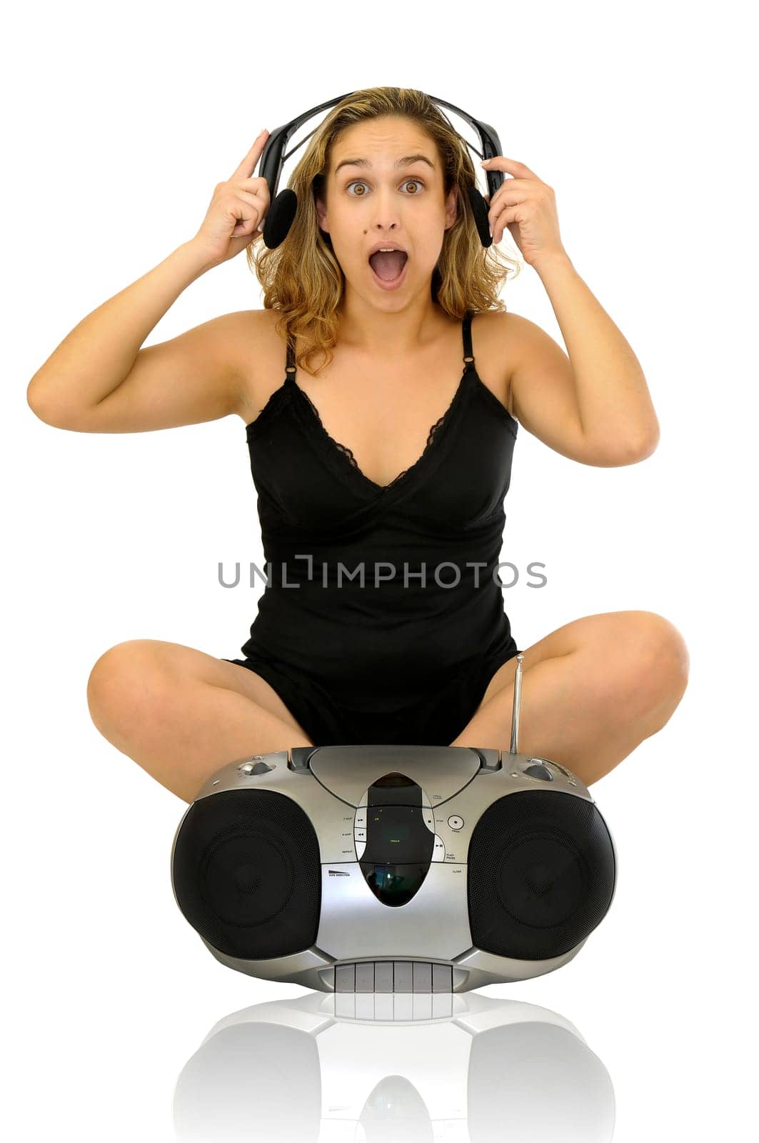 Beautiful young woman posing with a black dress and music stereo isolated in white