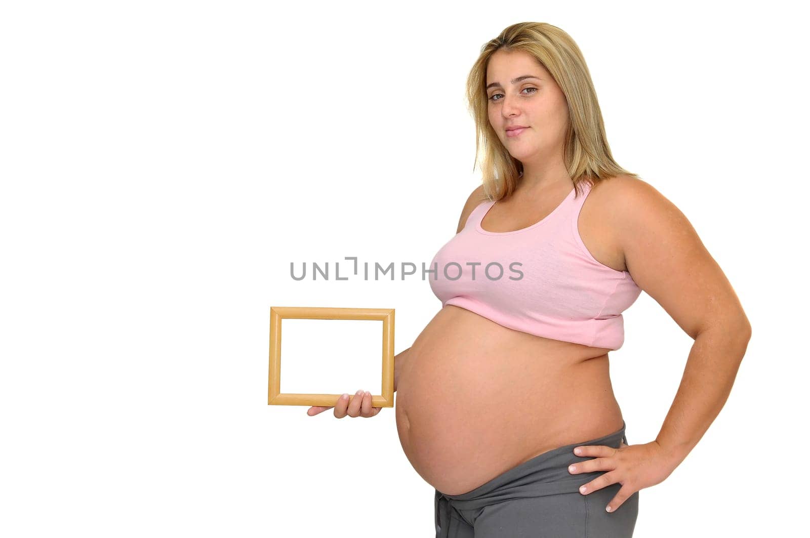 Pregnant woman holding a frame isolated in white
