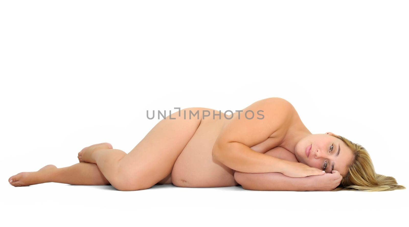 Beautiful pregnant naked woman posing laying down