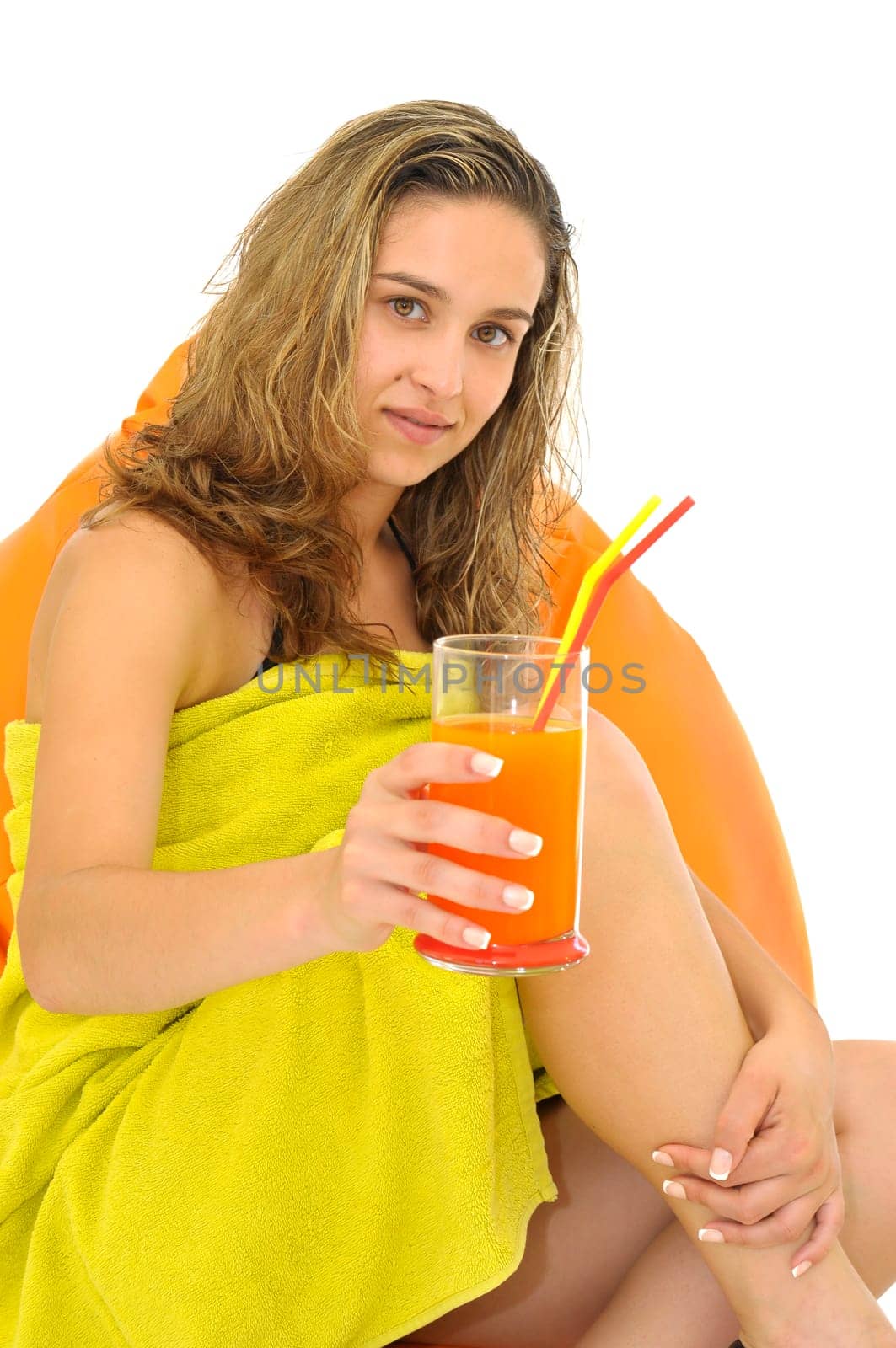 Sexy young girl with a natural juice glass and colorful towel isolated in white