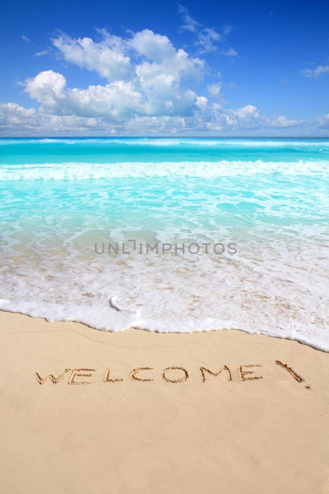 greetings welcome beach spell written on sand Caribbean tropical sea