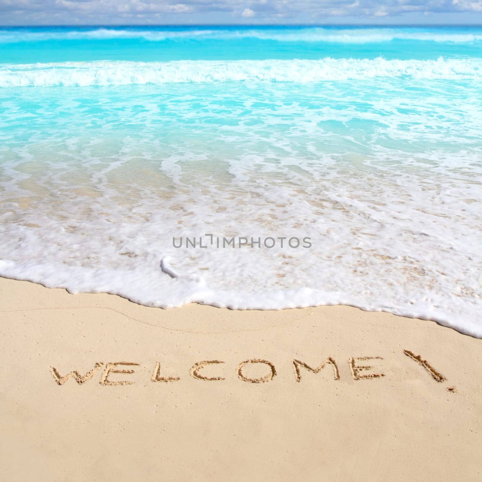 greetings welcome beach spell written on sand Caribbean tropical sea