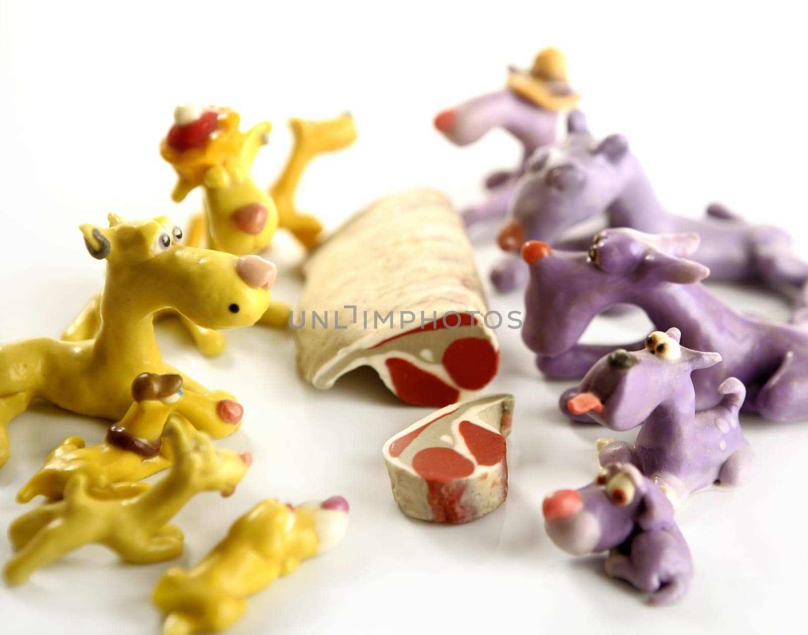 Handmade hungry plasticine dogs withy some meat to eat