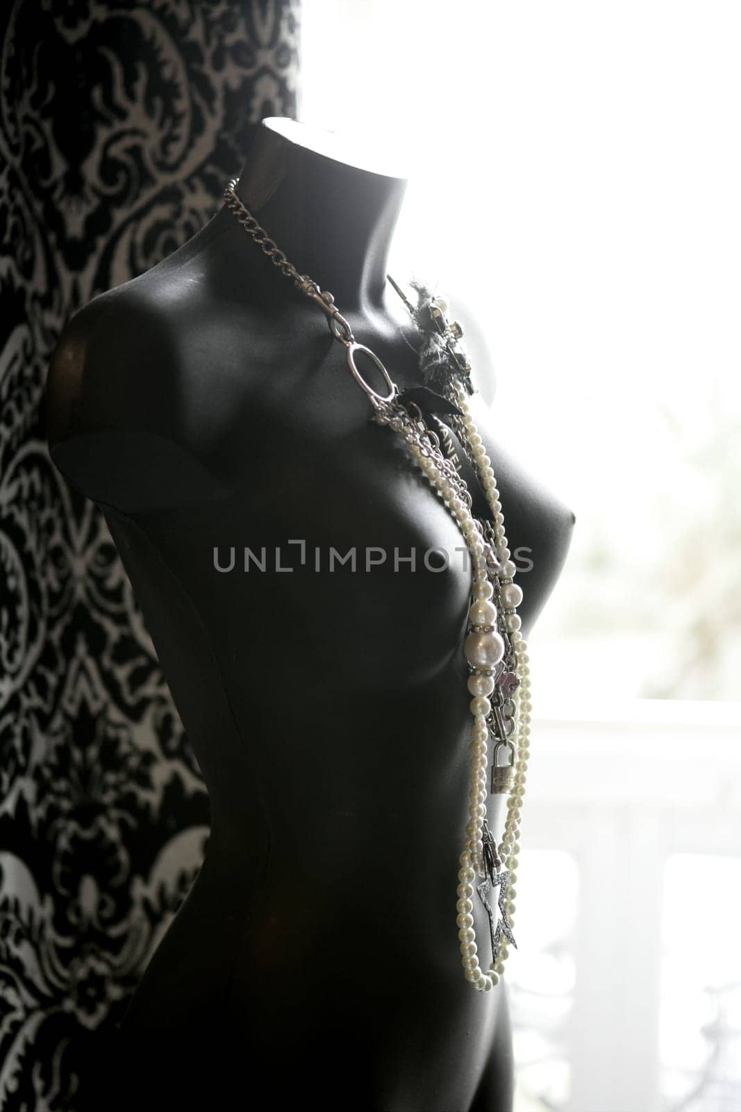 Black mannequin in backlit at natural light wearing nice jewelry