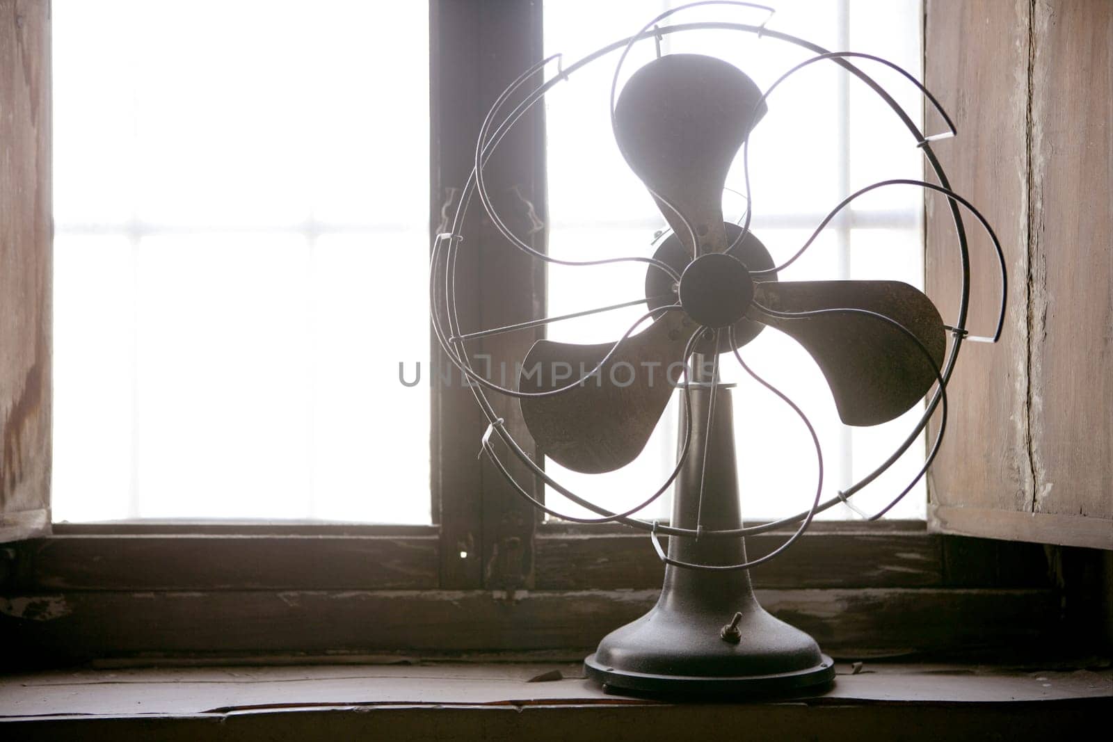 Antique vintage air fan in the window backlight