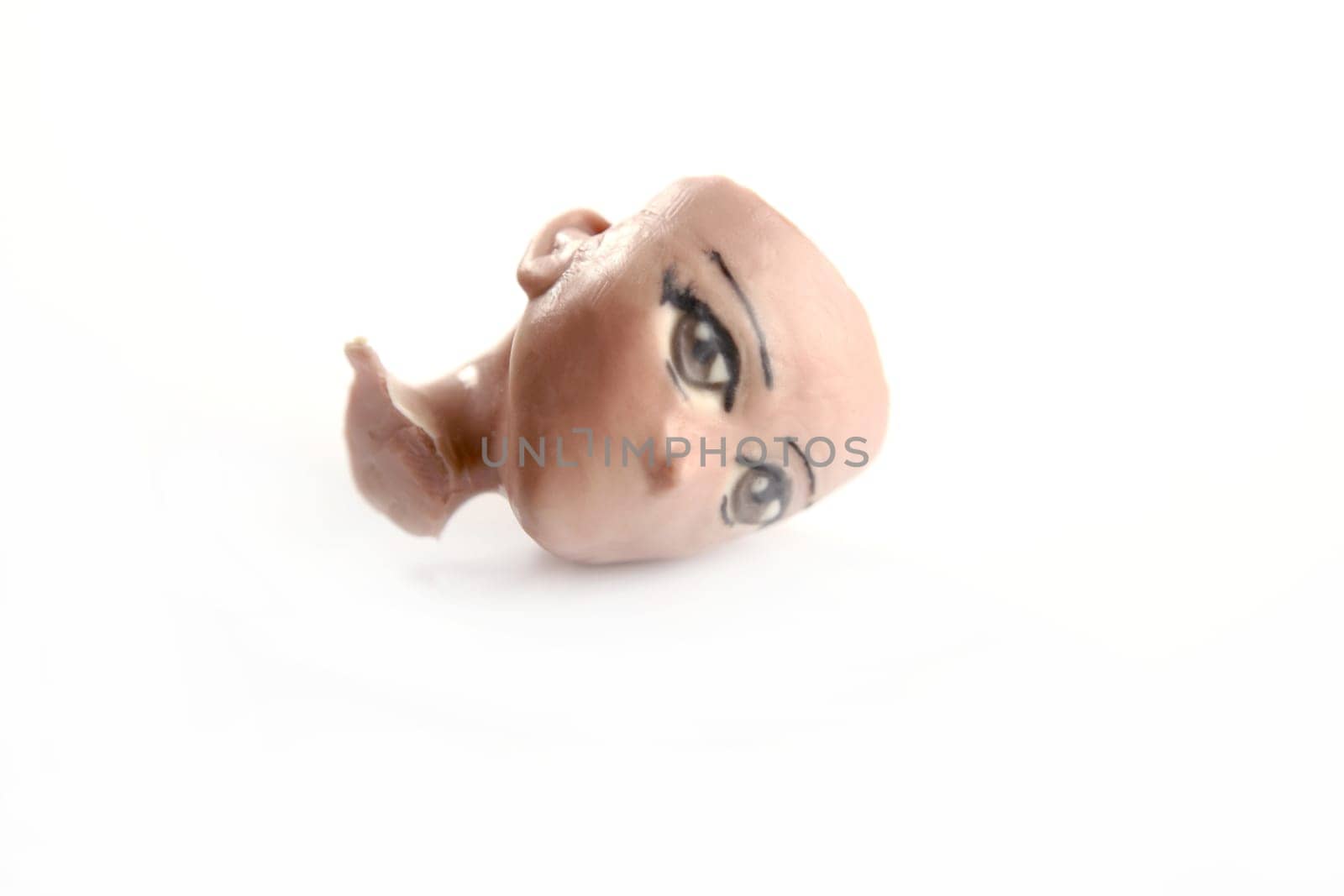 Handmade plasticine sculpture broken face replica isolated on white