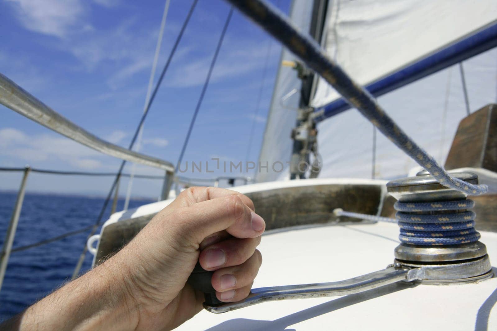 Blue summer water and sky in a sailboat race, sailor man in winch