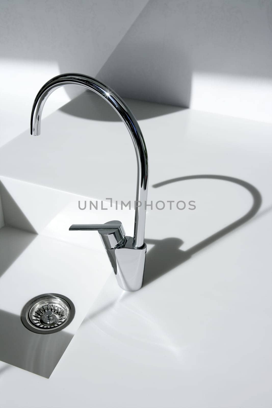 White modern kitchen detail, faucet and sink with shadows