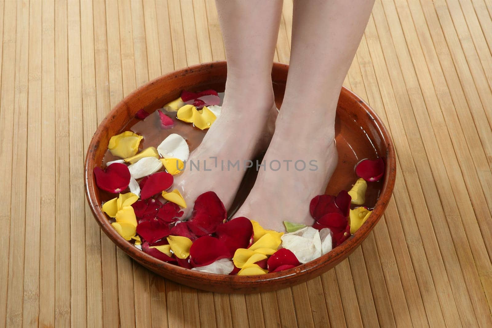 Aromatherapy, flowers woman feet bath, colorful rose petal