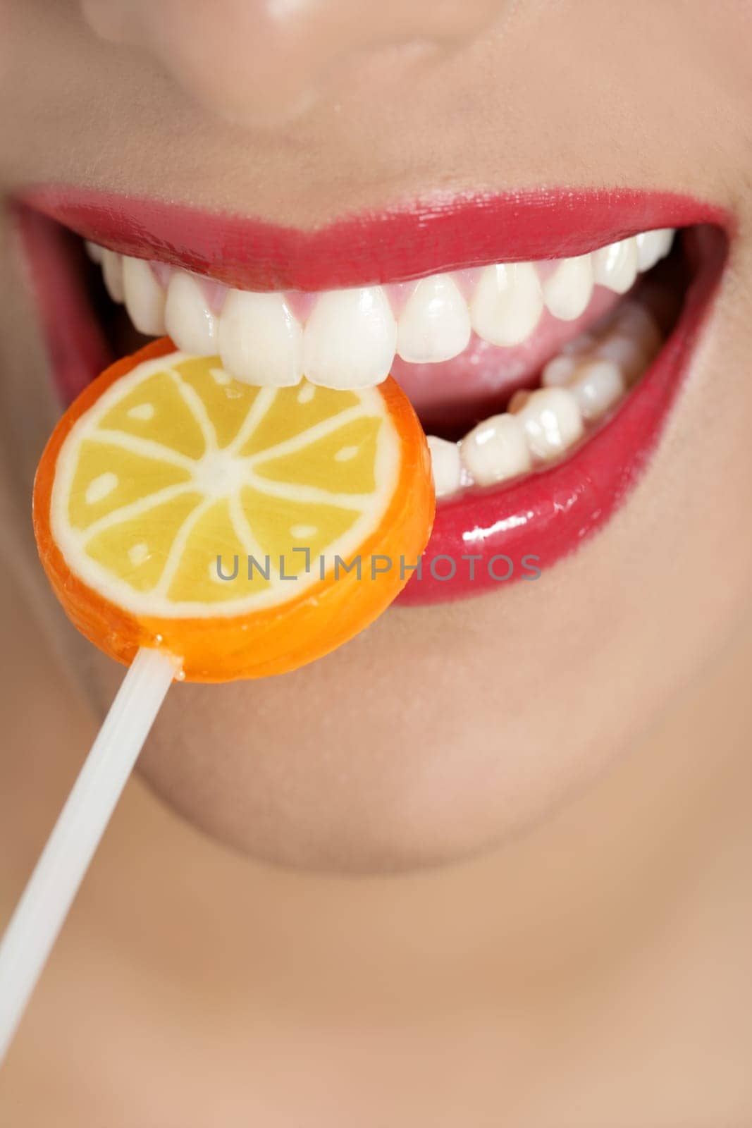 Colorful Lollypop in perfect woman teeth and red lips mouth