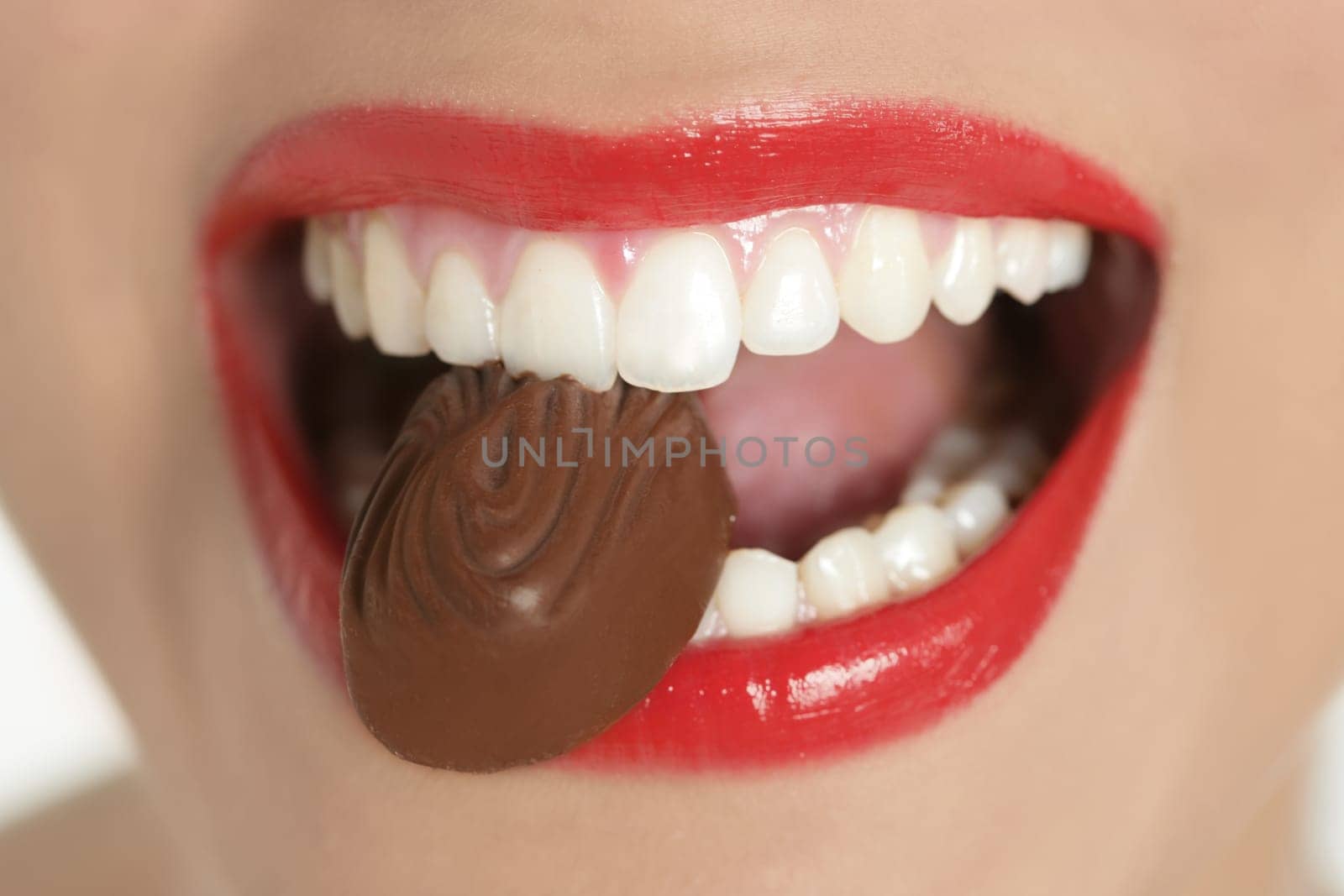 Chocolate sweet in beautiful woman mouth macro
