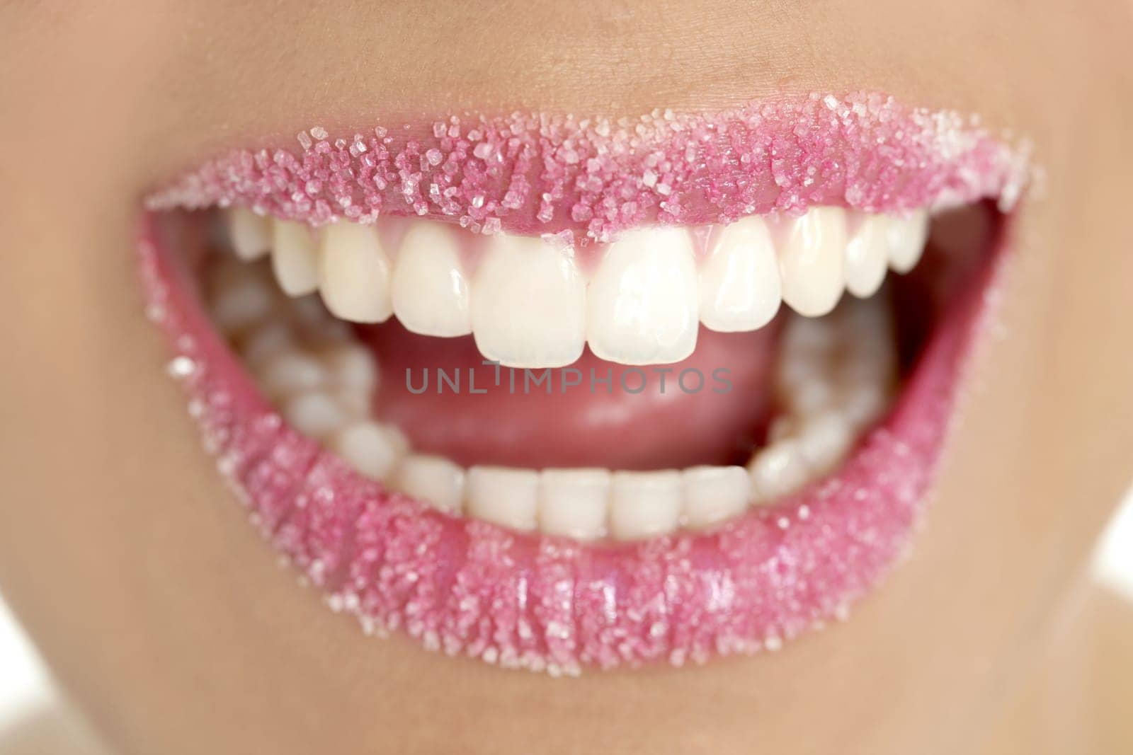 Lips of a woman in sugar pink liptstick makeup macro