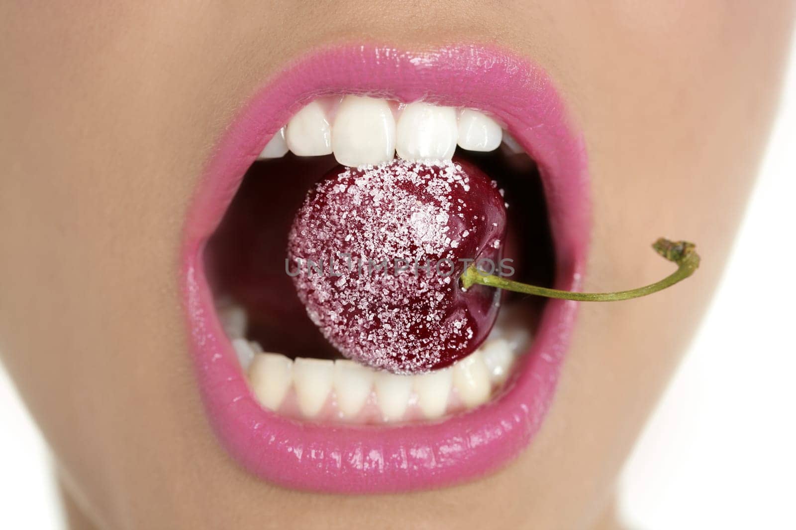 Cherry with sugar between woman perfect teeth macro