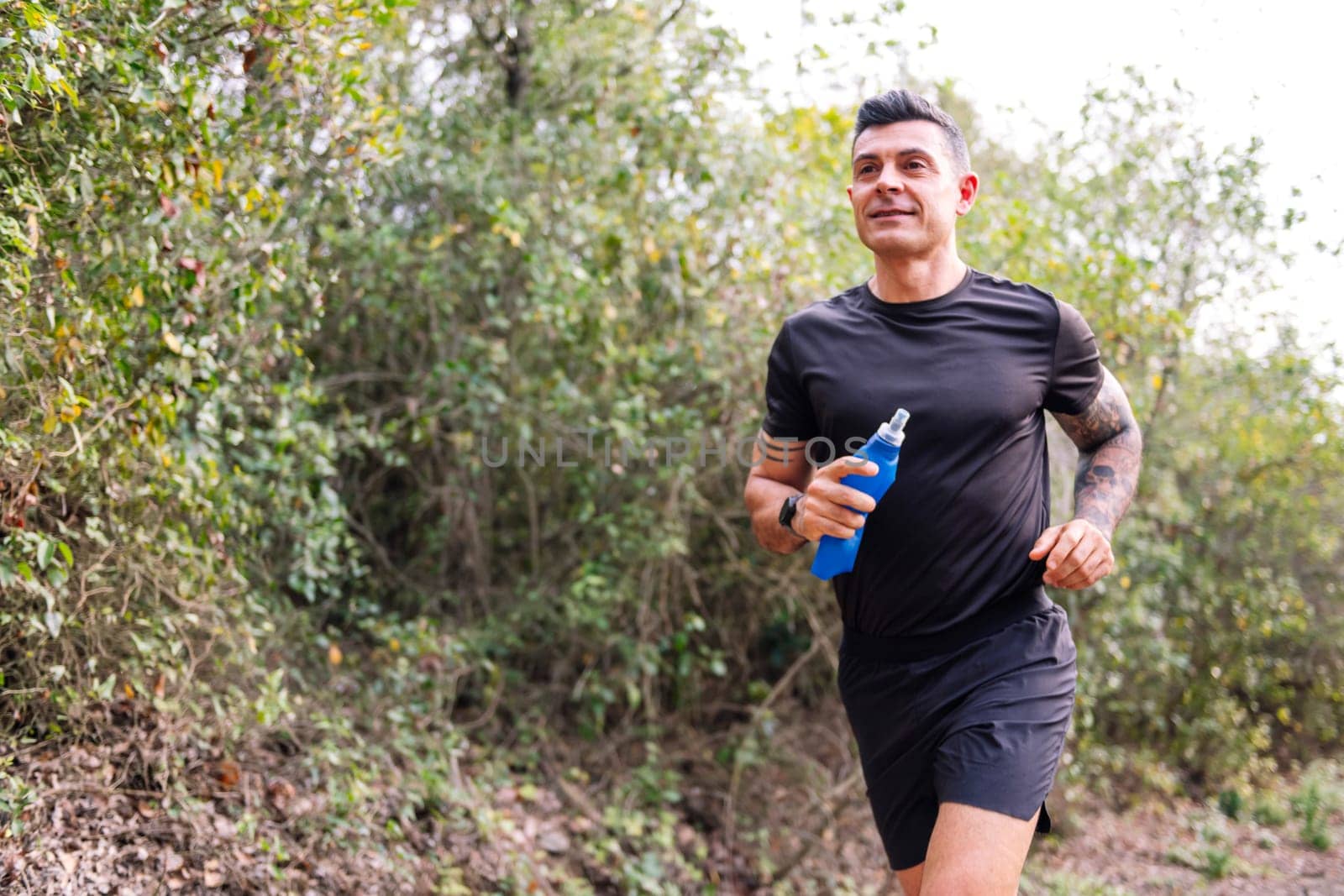 portrait of a man practicing trail running in the forest, concept of sport in nature and healthy lifestyle, copy space for text