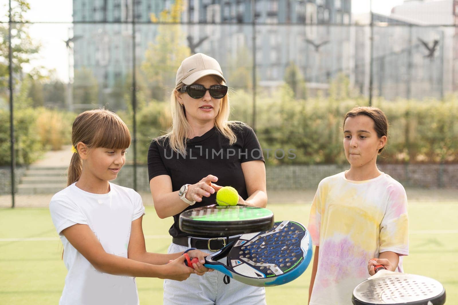 mother and daughters playing padel outdoor. High quality photo