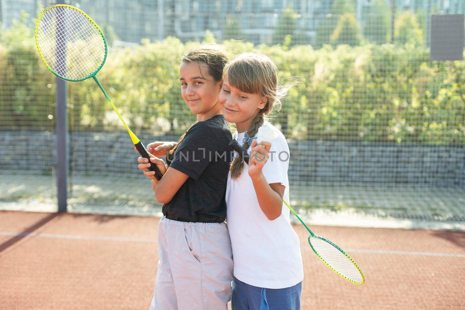 Two girls with badminton rackets on the football field. High quality photo