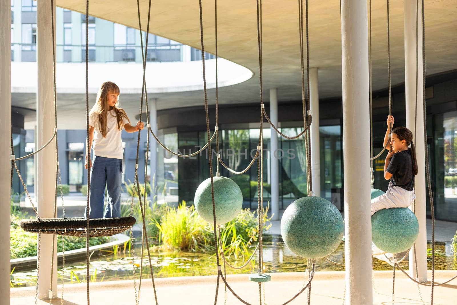 A schoolgirl plays on the playground in the city's backyard. High quality photo