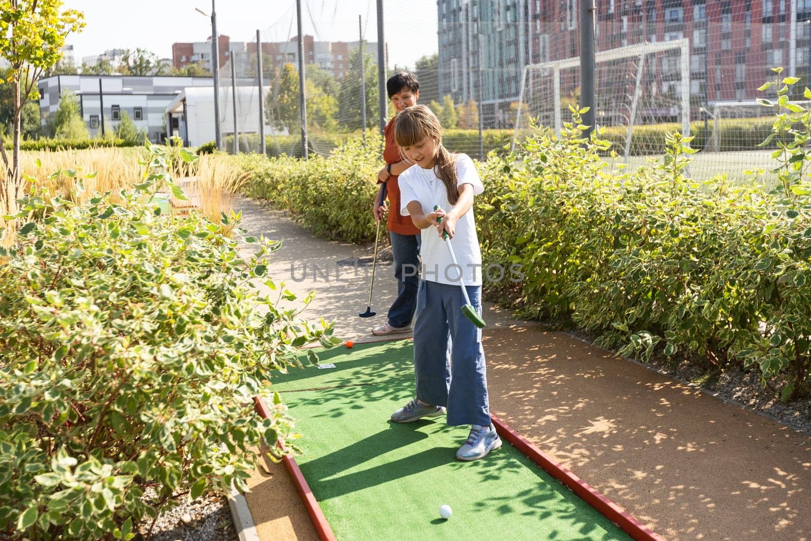 Kids playing golf inside playground artificial grass activity game for children by Andelov13