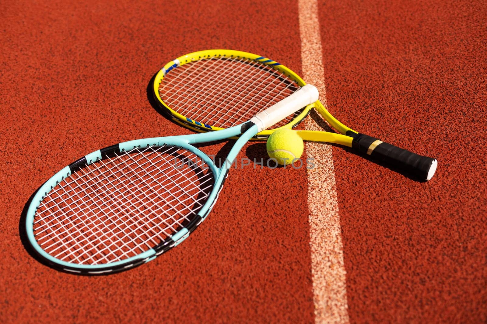 Close up view of tennis racket and balls on the clay tennis court. High quality photo