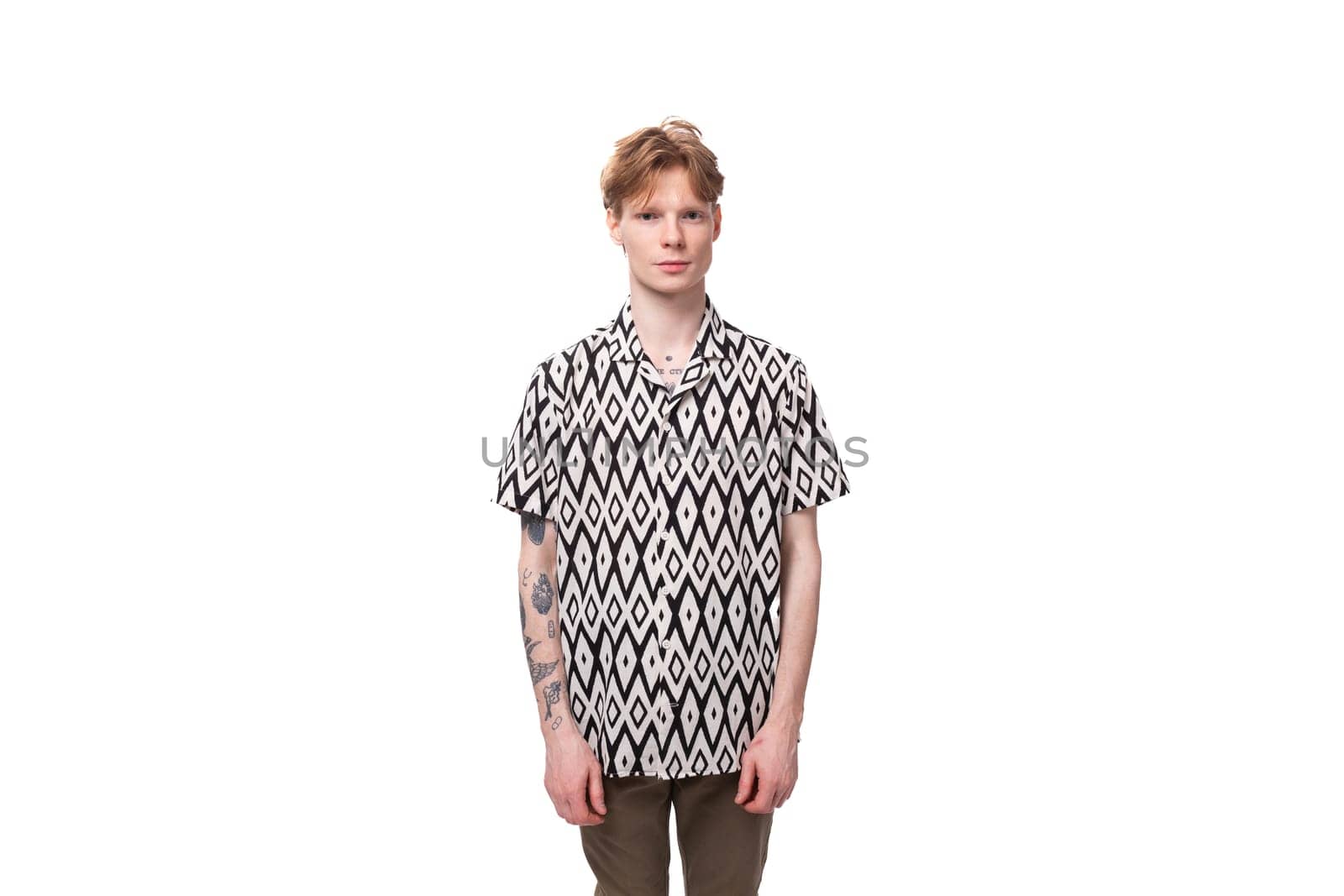 young red-haired man in a summer shirt with a rhombus print on a background with copy space.