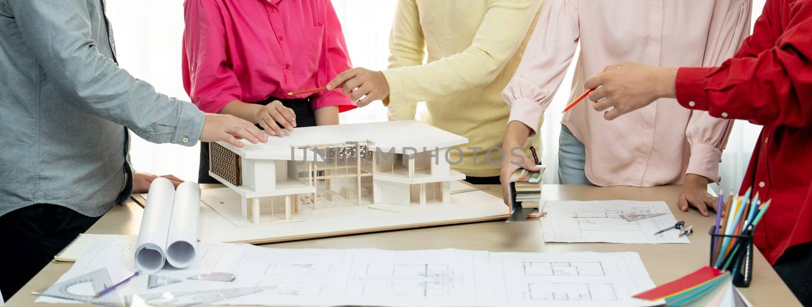 A cropped image of professional interior design team discuss about house material while smart engineer team brainstorm about house construction. Creative working and teamwork concept. Variegated