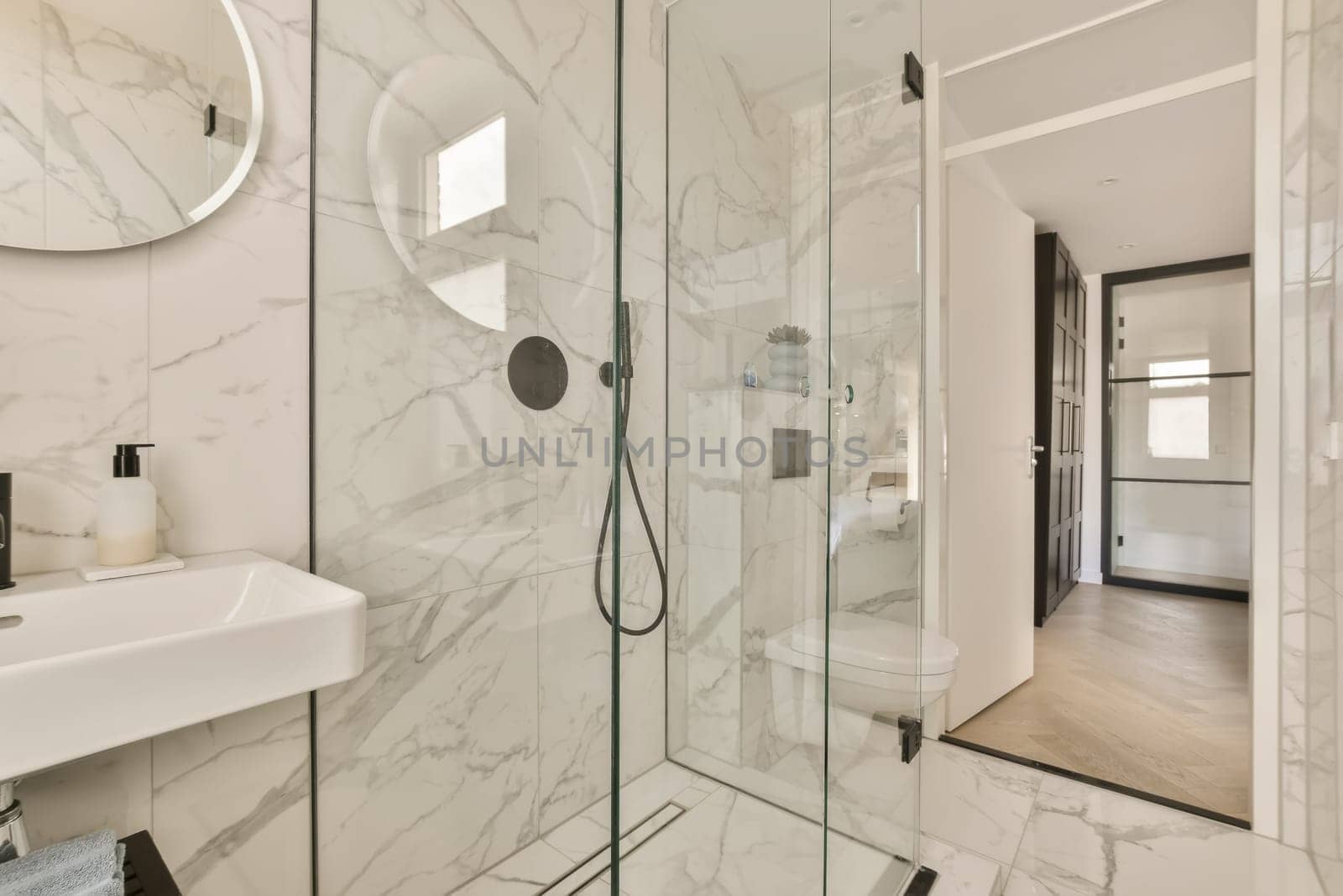 a modern bathroom with marble flooring and white walls there is a large mirror on the wall above the shower