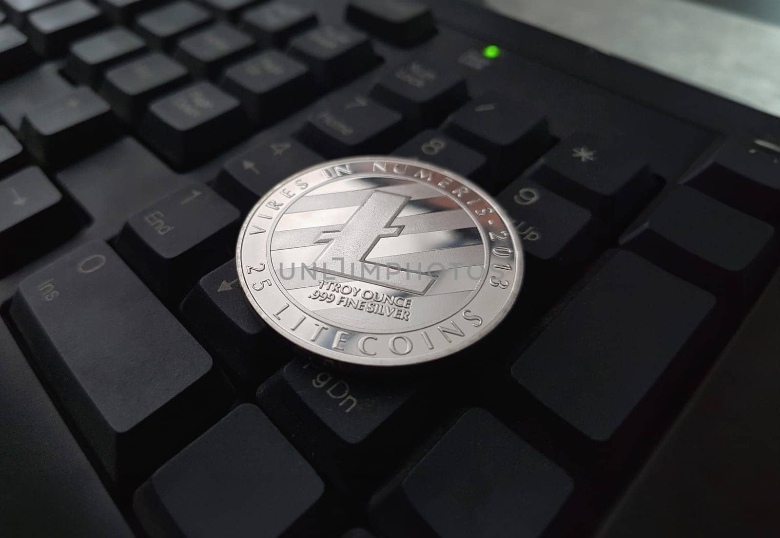 Coin crypto currency Litecoin lies on the keyboard background theme gold exchange pyramid for money due to rise or fall exchange rate closeup