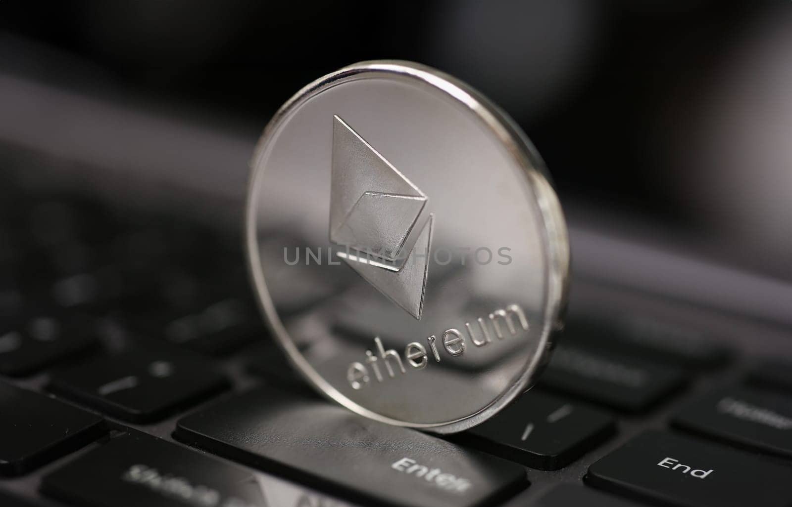 Coin crypto currency ethereum lies on the keyboard background theme of the silver. Exchange pyramid for money due to the rise or fall of the exchange rate.
