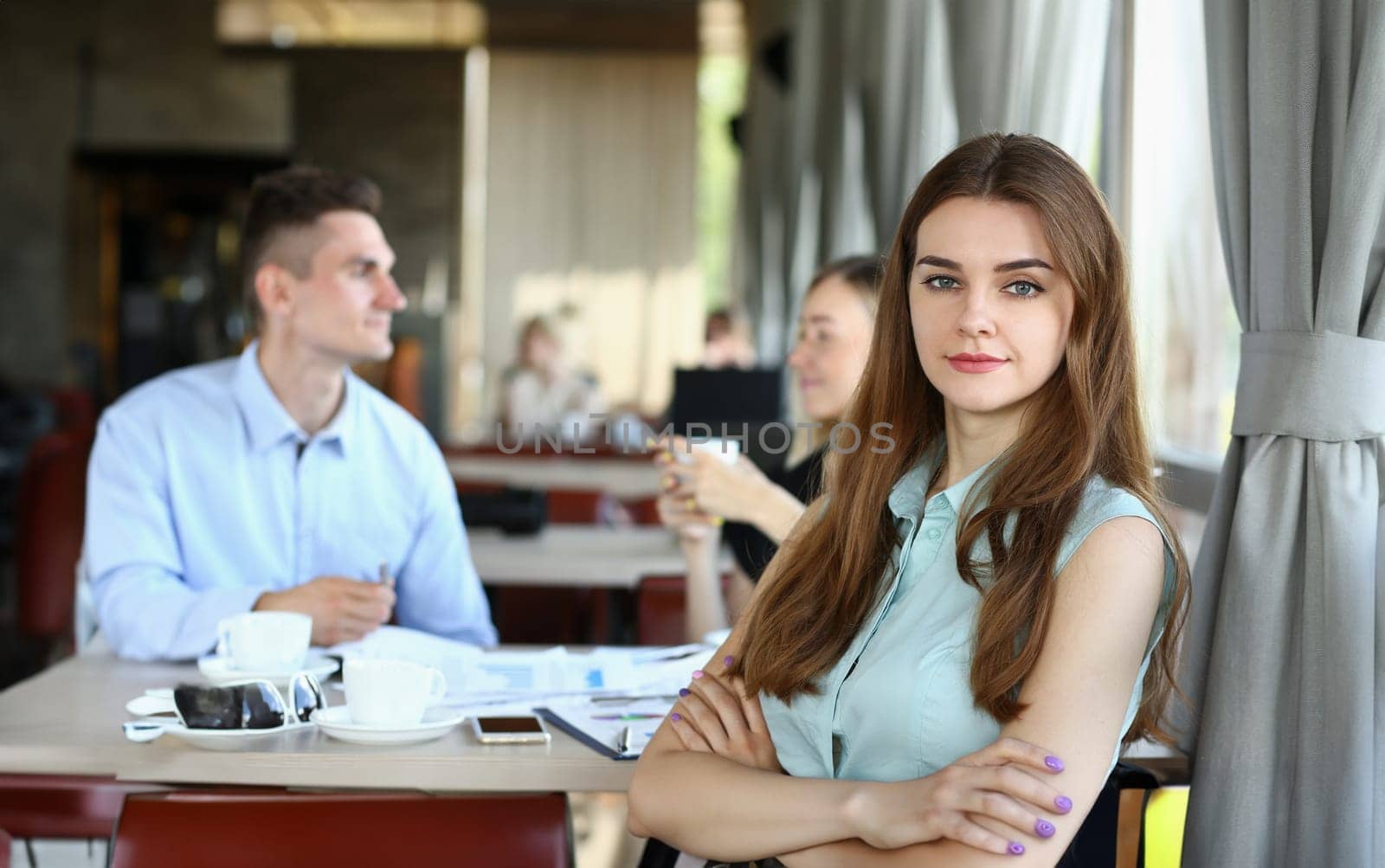 beautiful woman have meeting with her subordinates in cafe by kuprevich