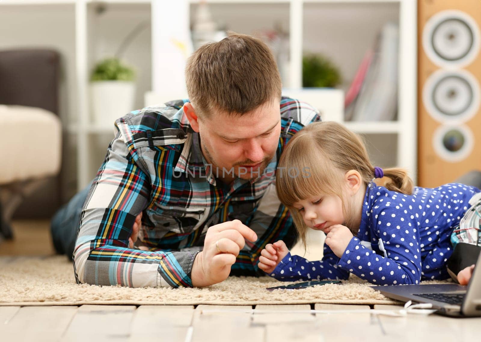 Cute little girl on floor carpet with dad use cellphone calling mom portrait. Life style apps social web network wireless ip telephony concept