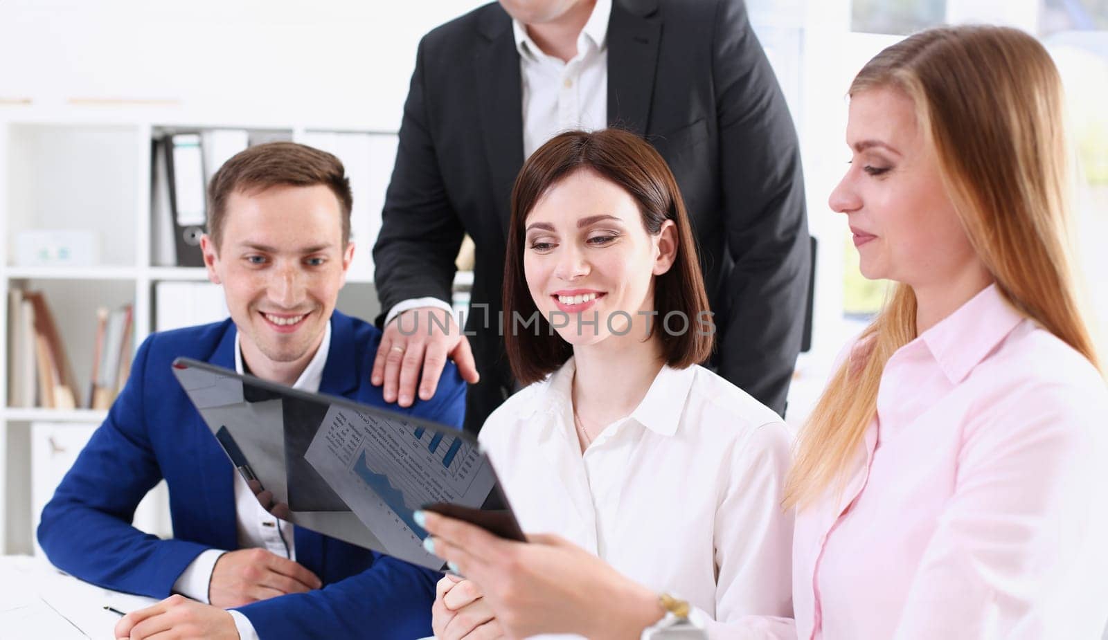 Group of people in office look at mobile tablet pc by kuprevich