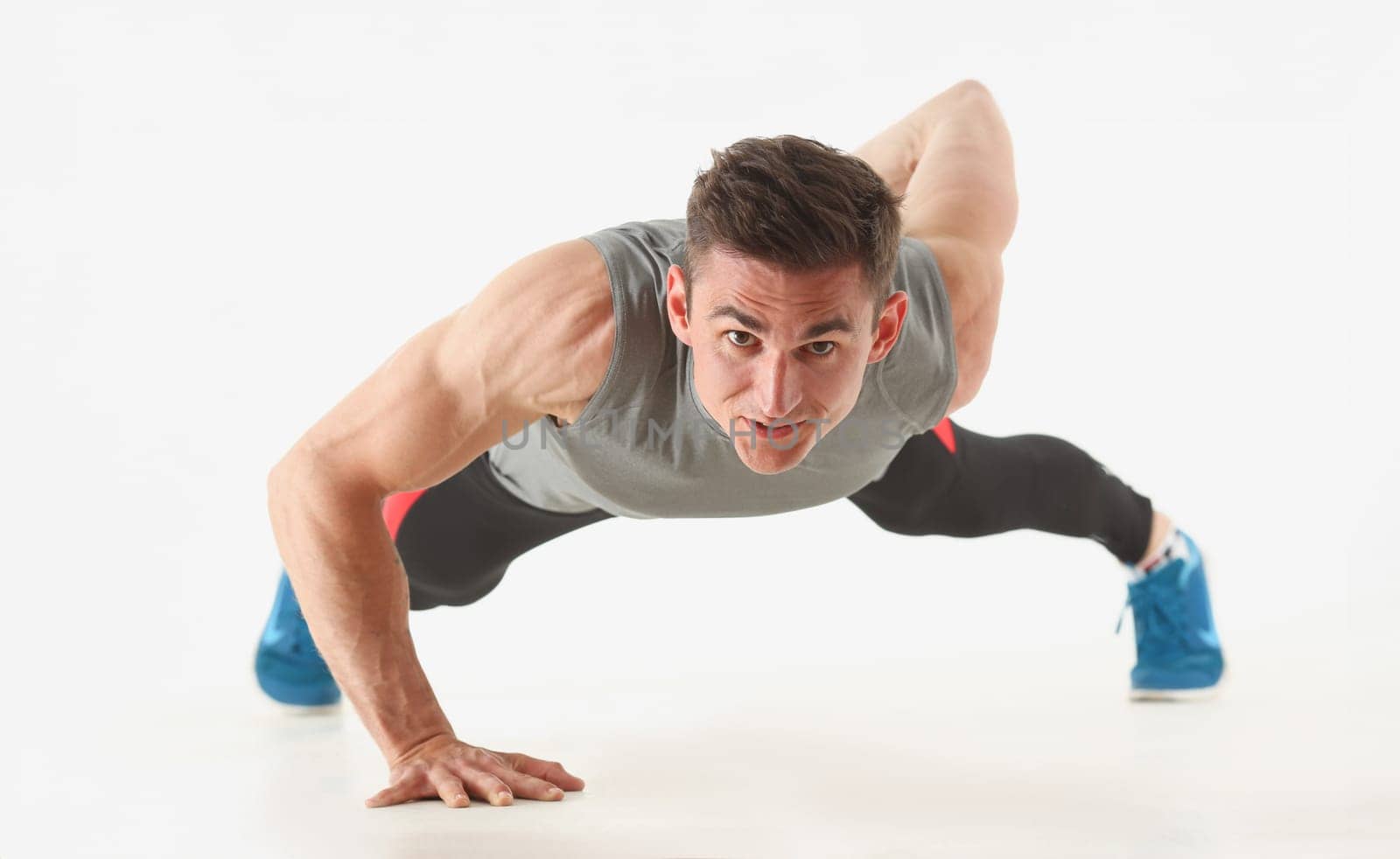 Fitness man wringing from the floor demonstrates good physical exercises isolated on white background. Healthy lifestyle for many people exercising their own weight for losing for every day push up.