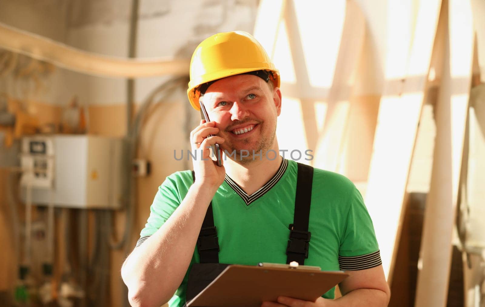 Carpenter talking on phone in hardware store furniture manufacturing takes an order