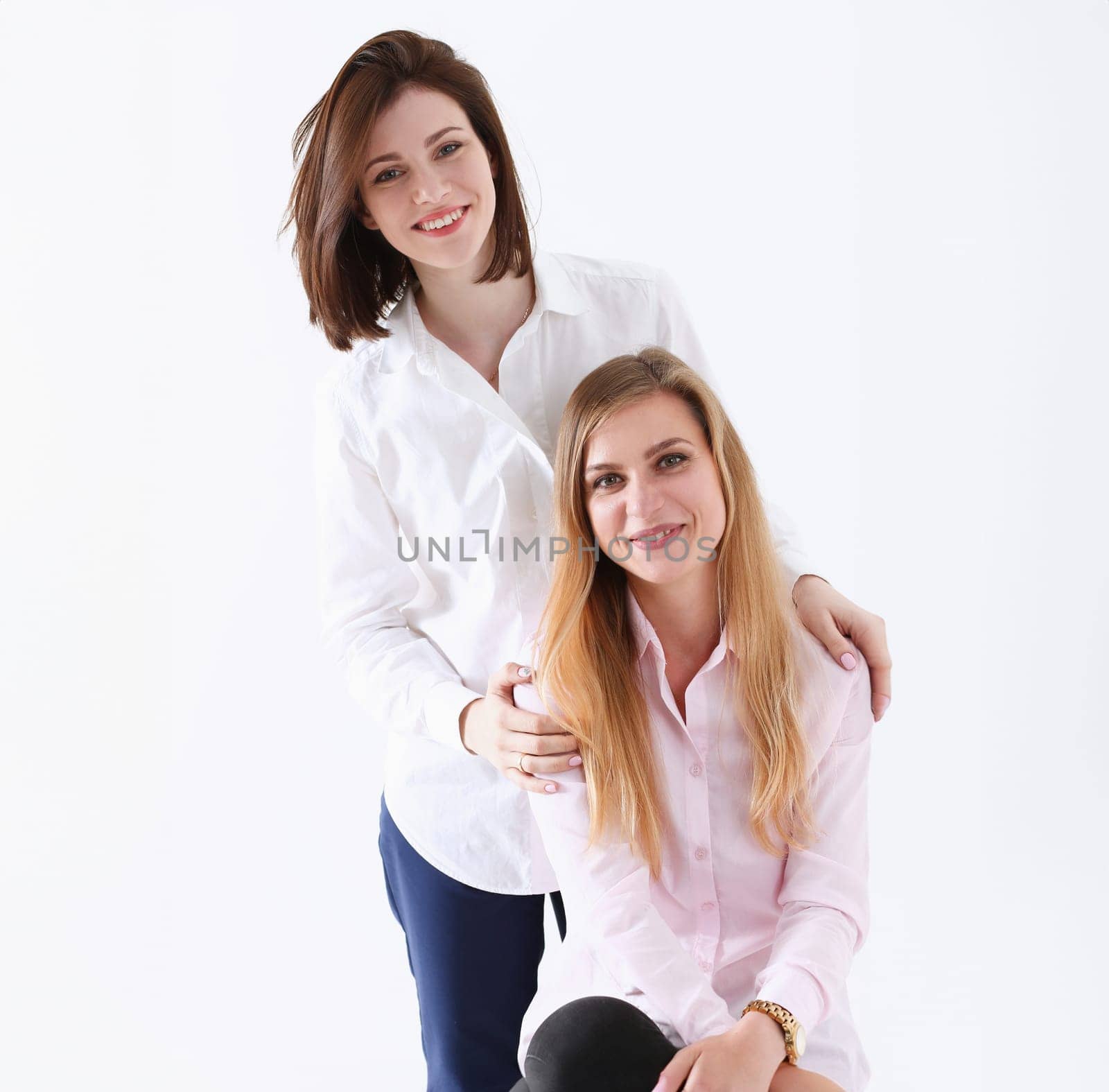 Two smiling happy joyful female friends portrait looking in camera over white background. Homosexual marriage lesbian couple love relations modern positive relationship concept