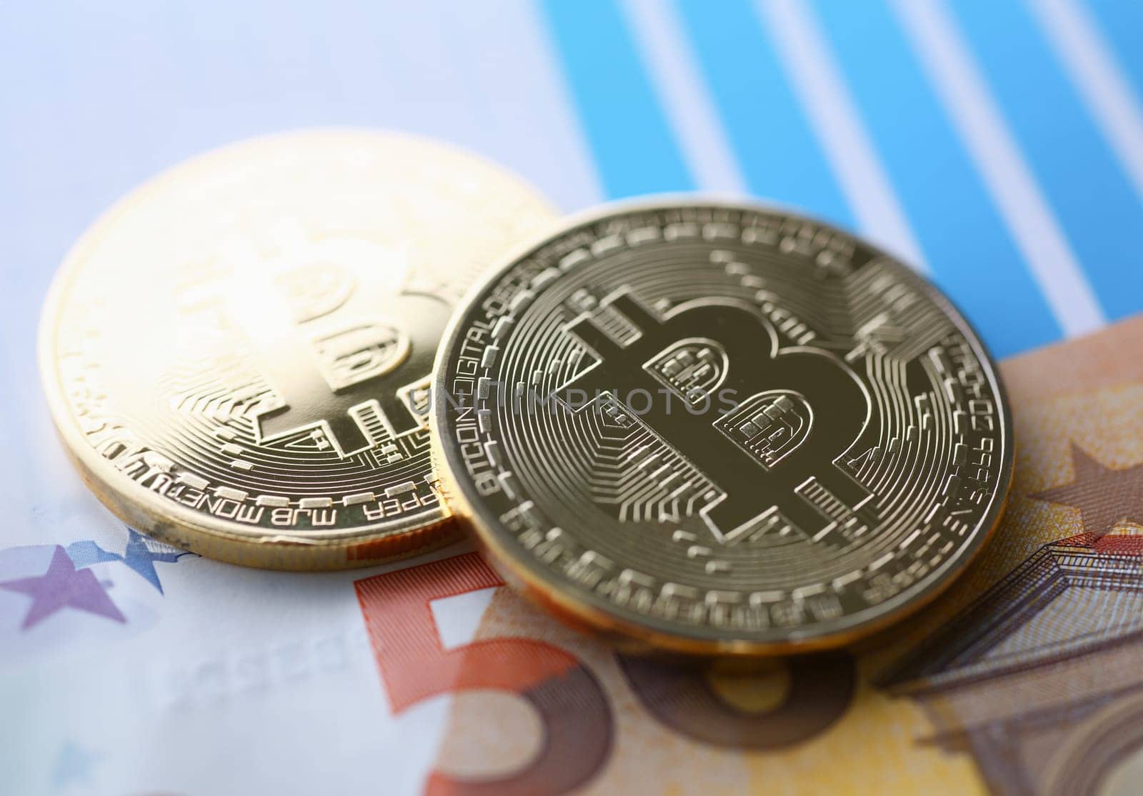 The coin of crypto currency bitcoin against background euro banknote subject gold. Exchange pyramid for money in connection with the growth or fall exchange rate closeup.