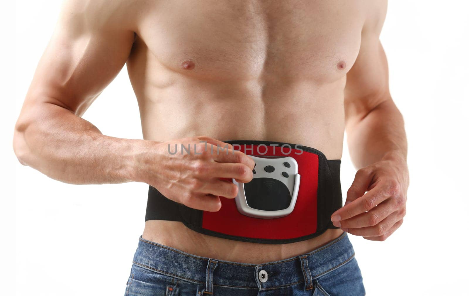 Athletic folded man uses an electric belt simulator for training a press