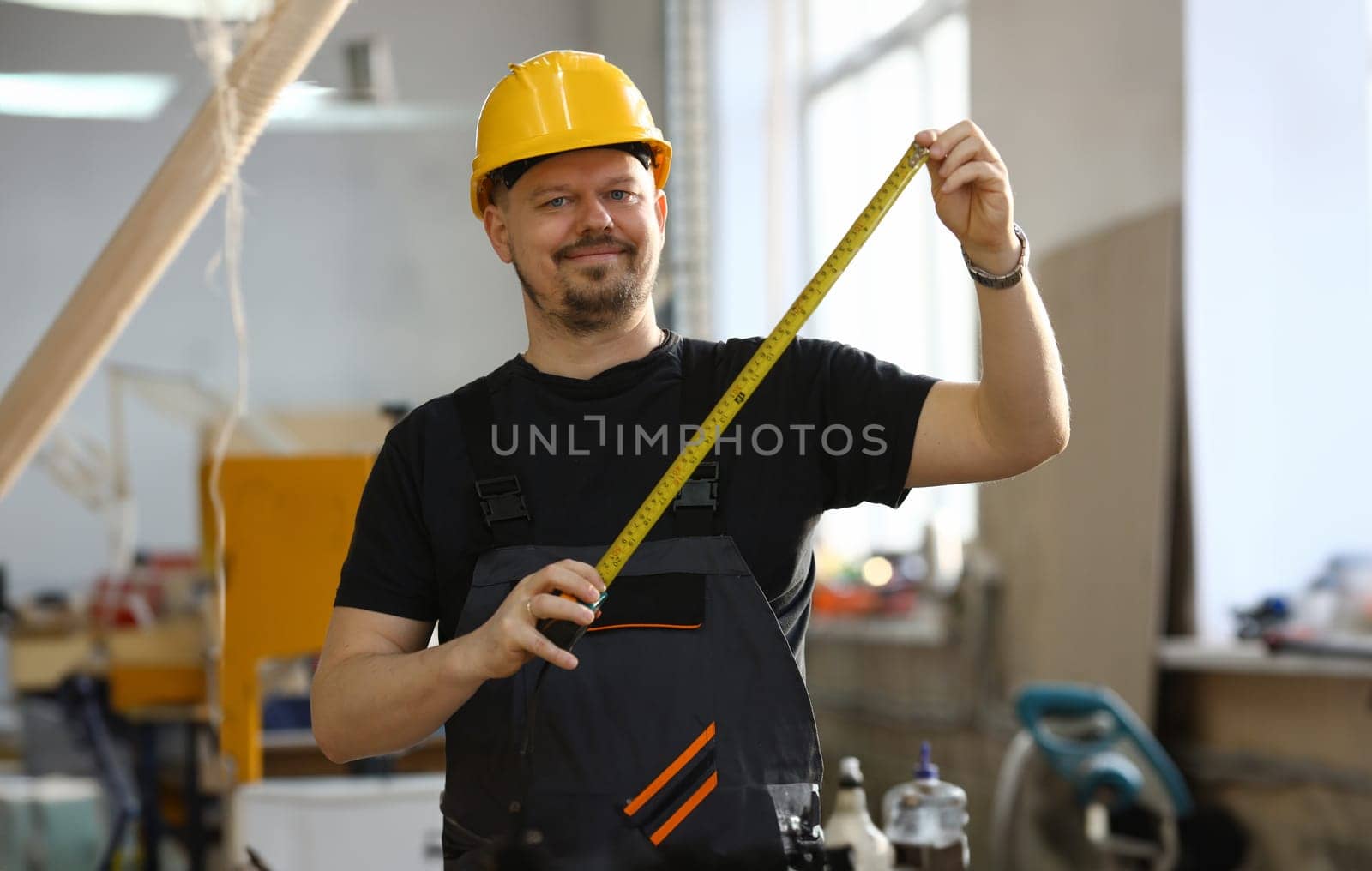 Handsome worker measuring. Manual job DIY inspiration improvement job fix shop yellow helmet joinery startu workplace idea designer career ruler industrial education