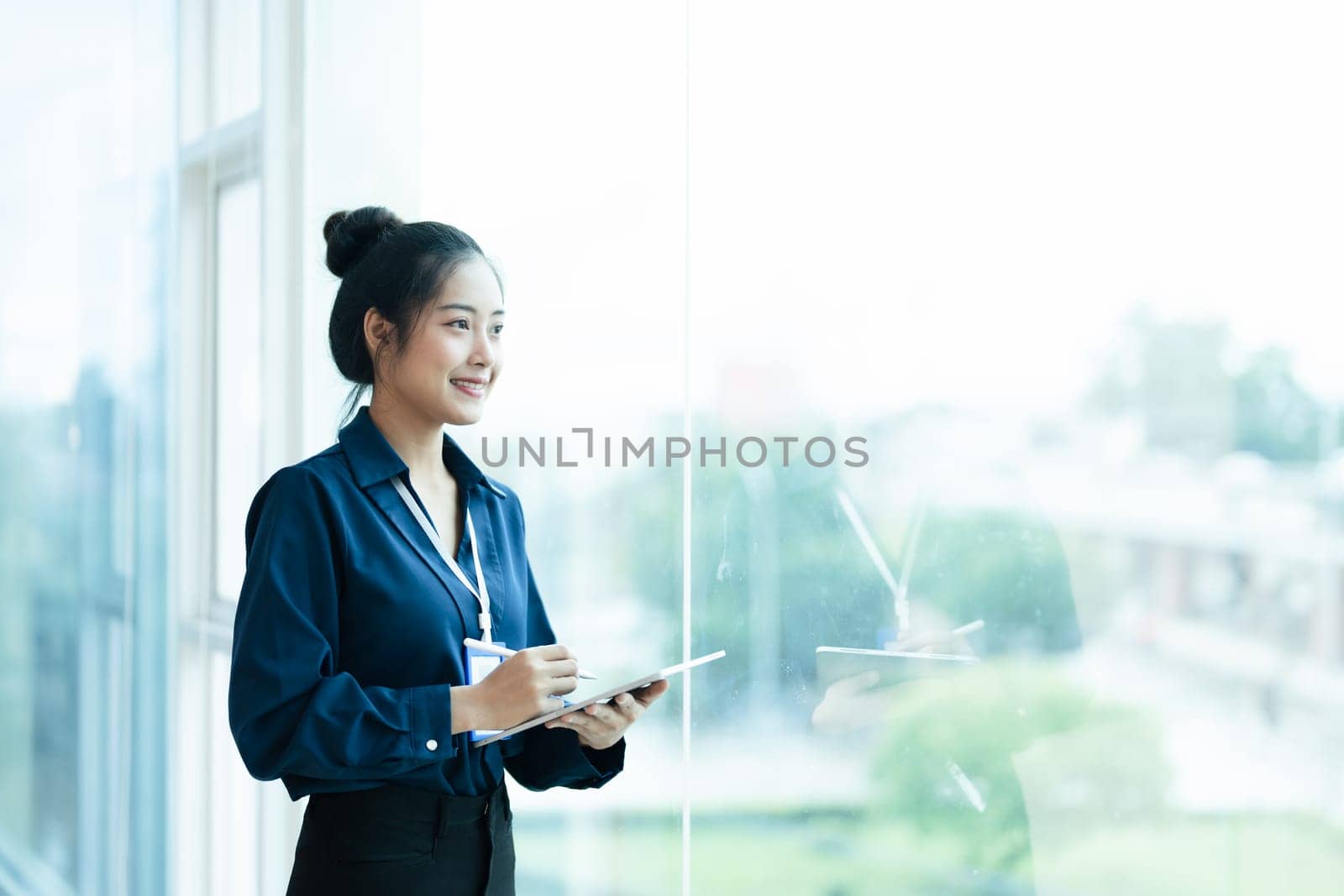 Portrait of a woman business owner showing a happy smiling face as he has successfully invested her business using financial budget documents at work by Manastrong