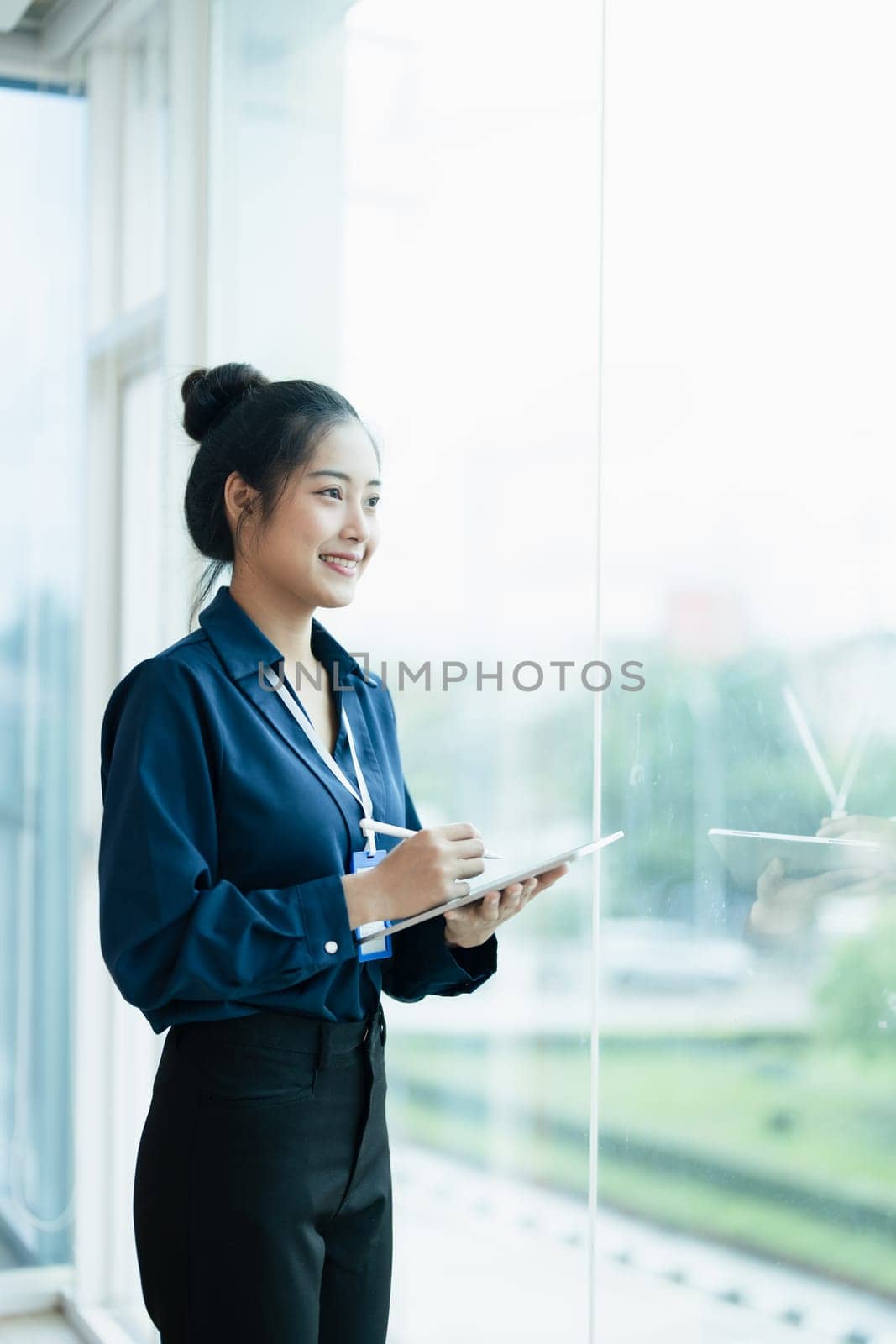 Portrait of a woman business owner showing a happy smiling face as he has successfully invested her business using financial budget documents at work by Manastrong