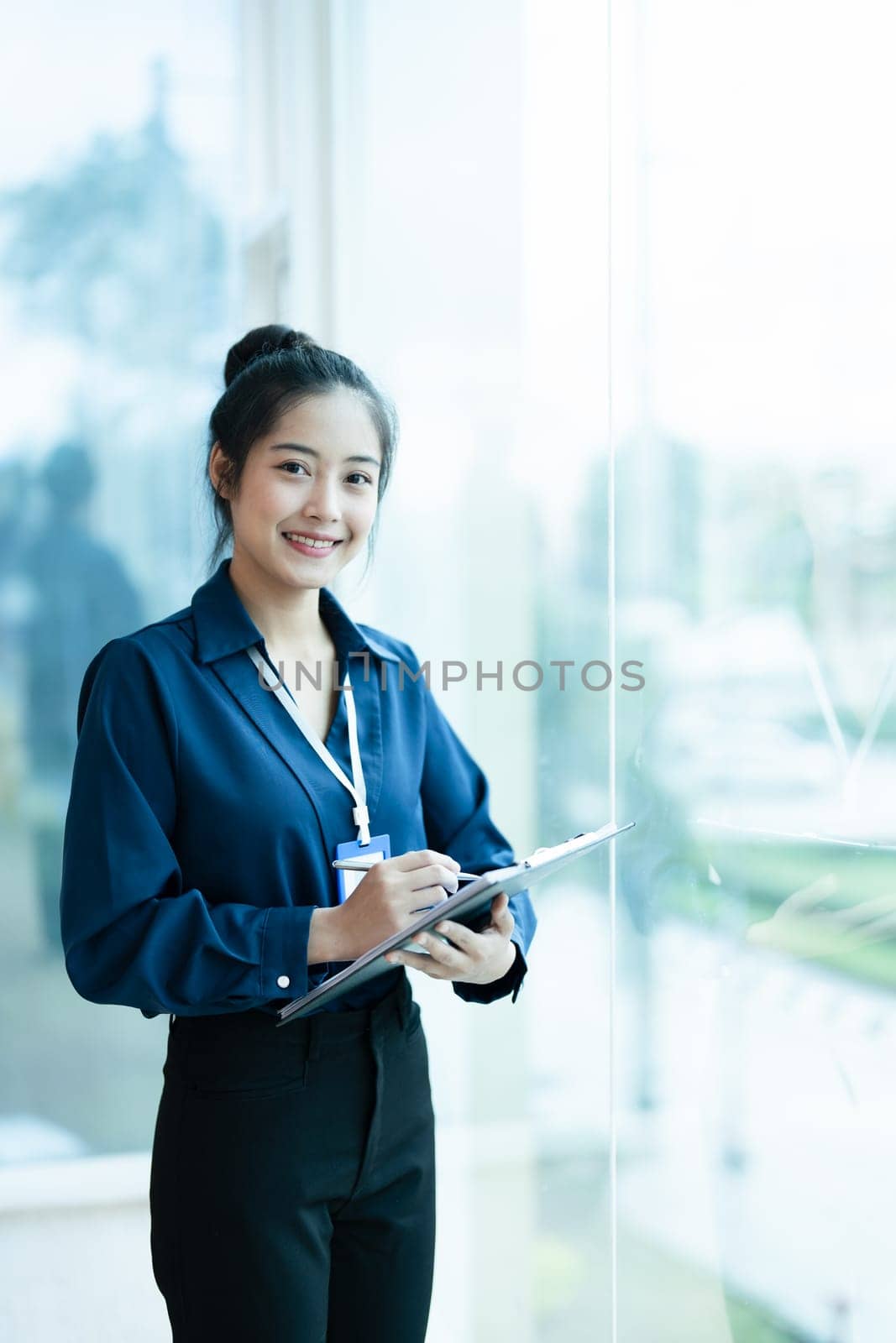 Portrait of a woman business owner showing a happy smiling face as he has successfully invested her business using financial budget documents at work.