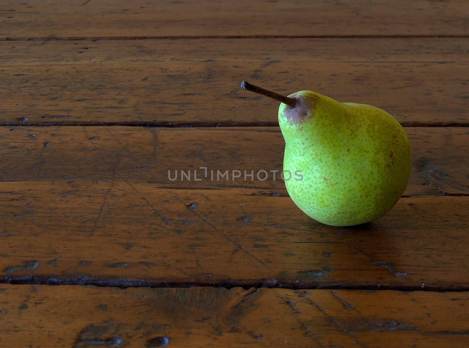 one pear on old antique wood table