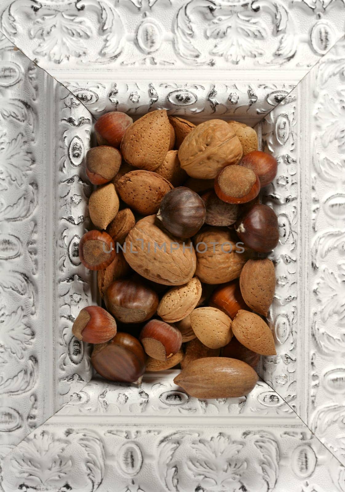 wooden decorated classic white frame, varied nuts inside