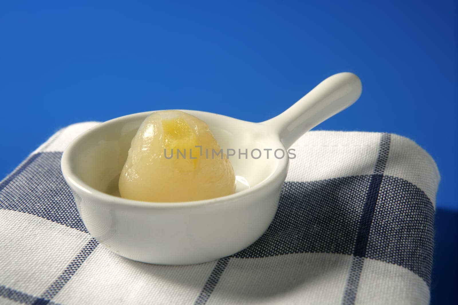 Rambutan, lychee with pineapple inside dessert, over blue