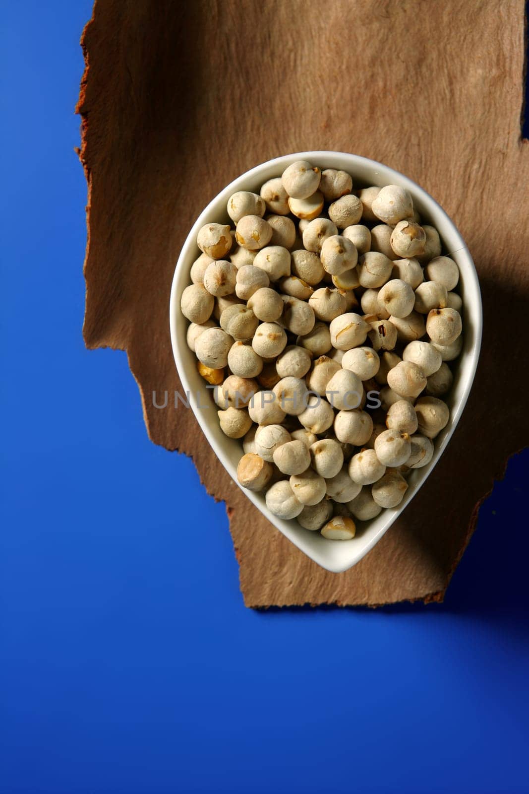 Chickpeas in a bowl over wood and blue background