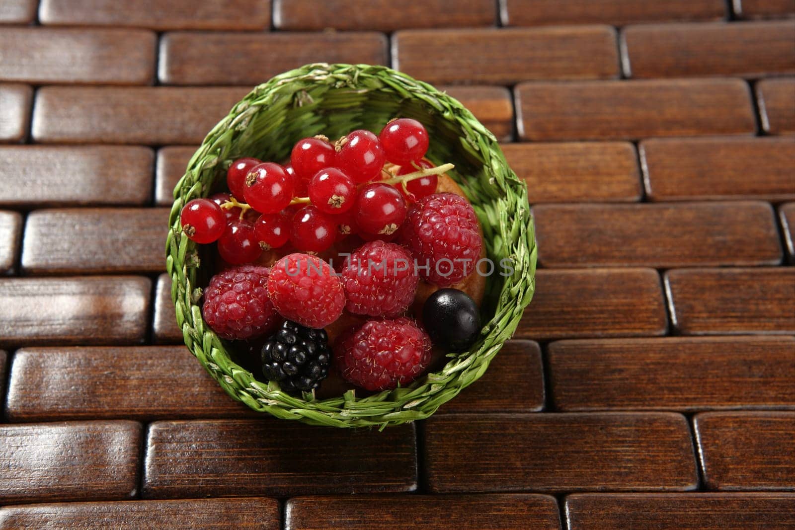 Mixed forest berries dessert  in a green little basket