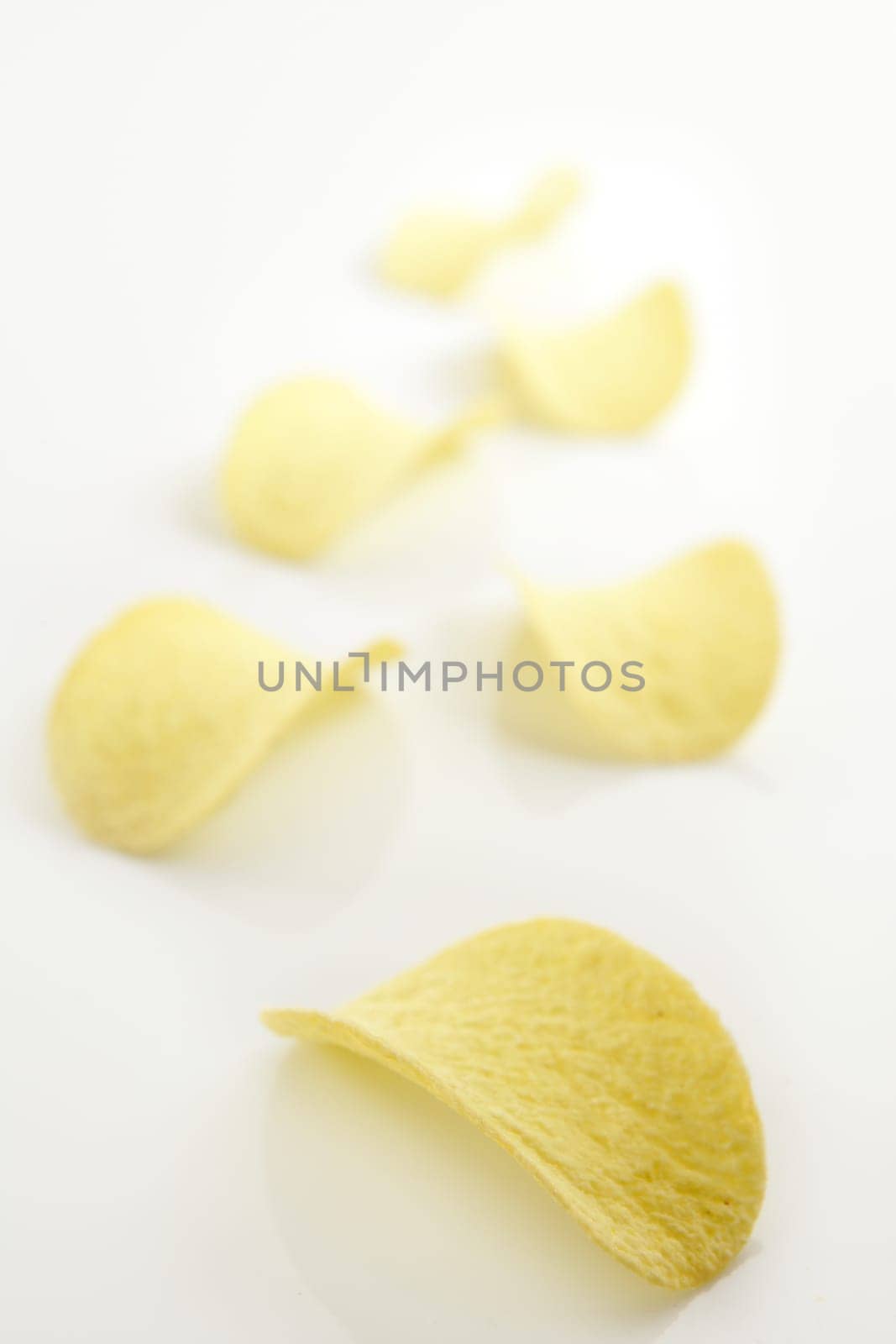 Potato salted chips slices over white background