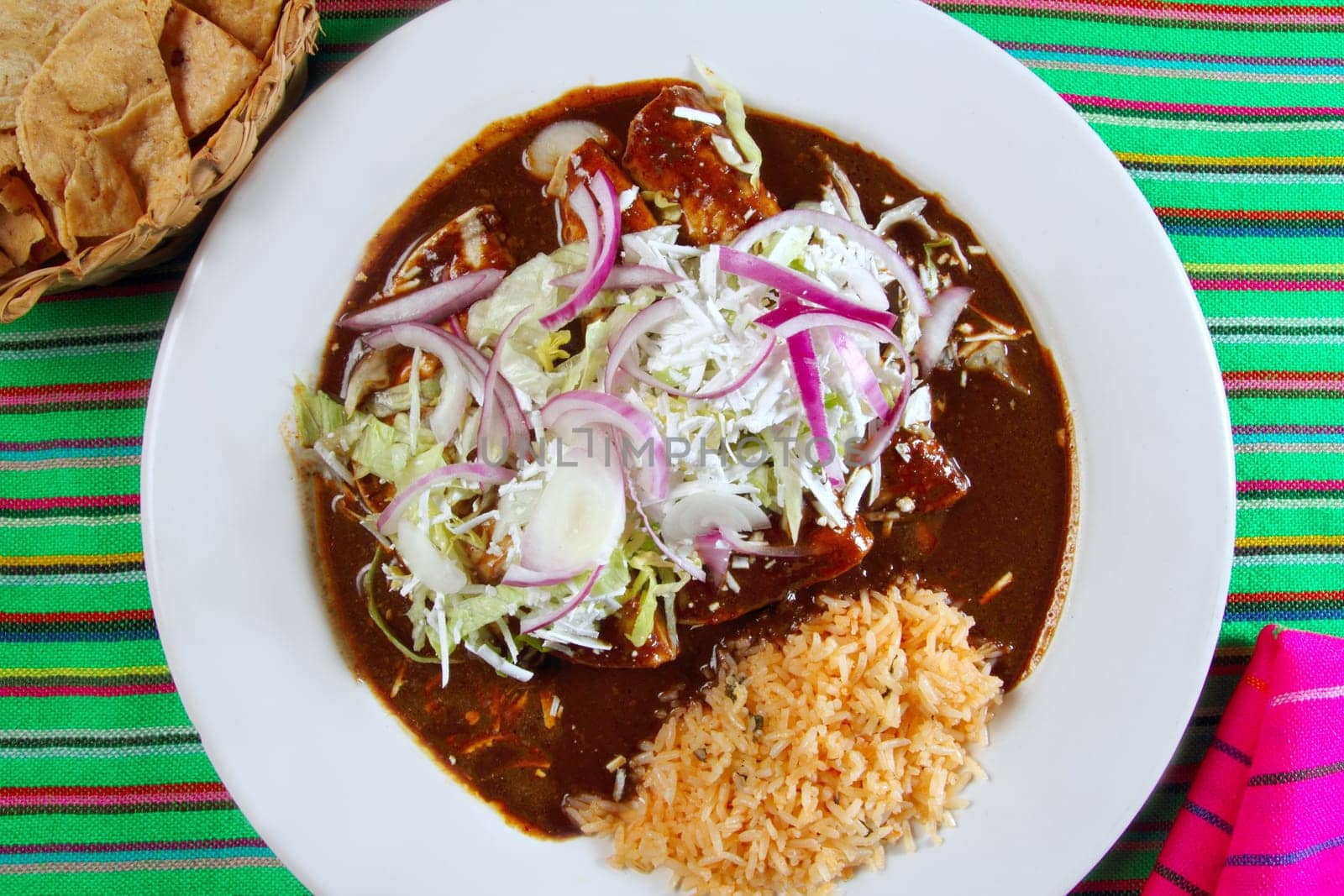 enchiladas of mole and rice Mexican food colorful tablecloth