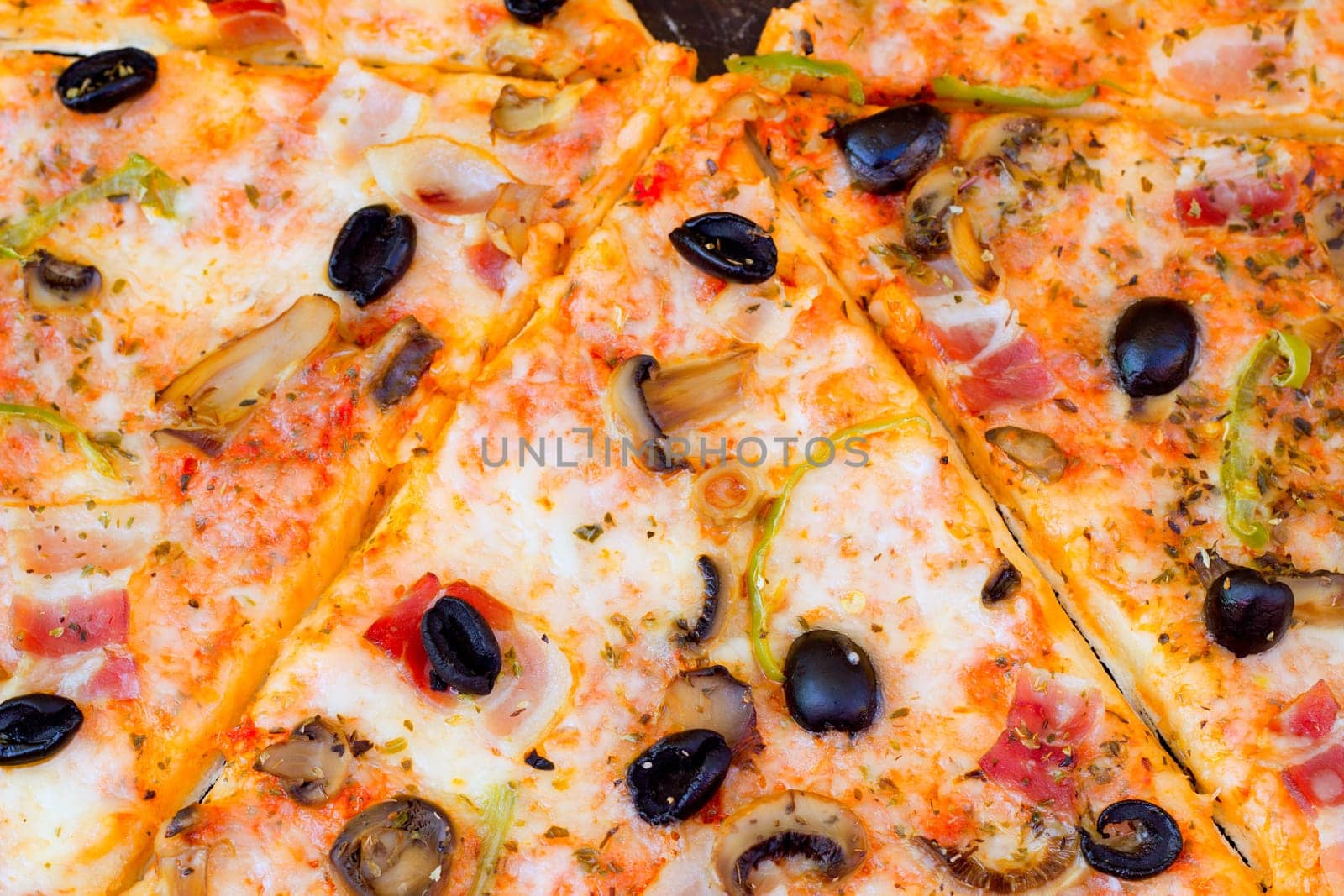 closeup of pizza with olives tomato cheese pepper and mushrooms