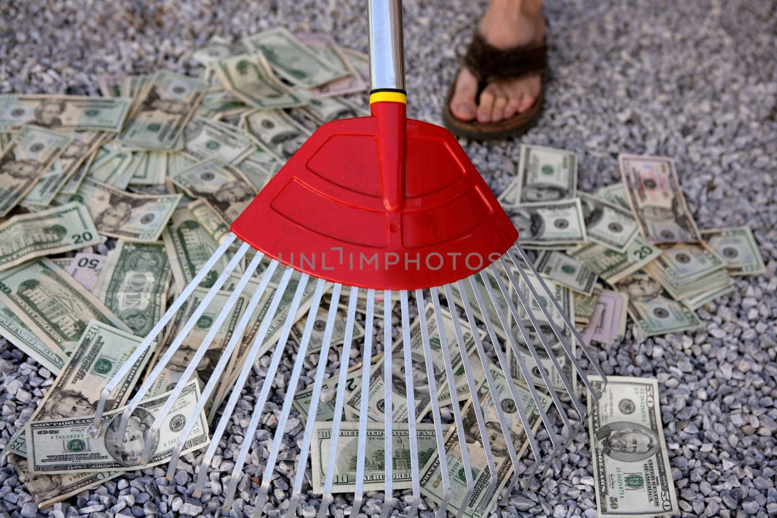 Cleaning black dolar money with rake, metaphor of abundance